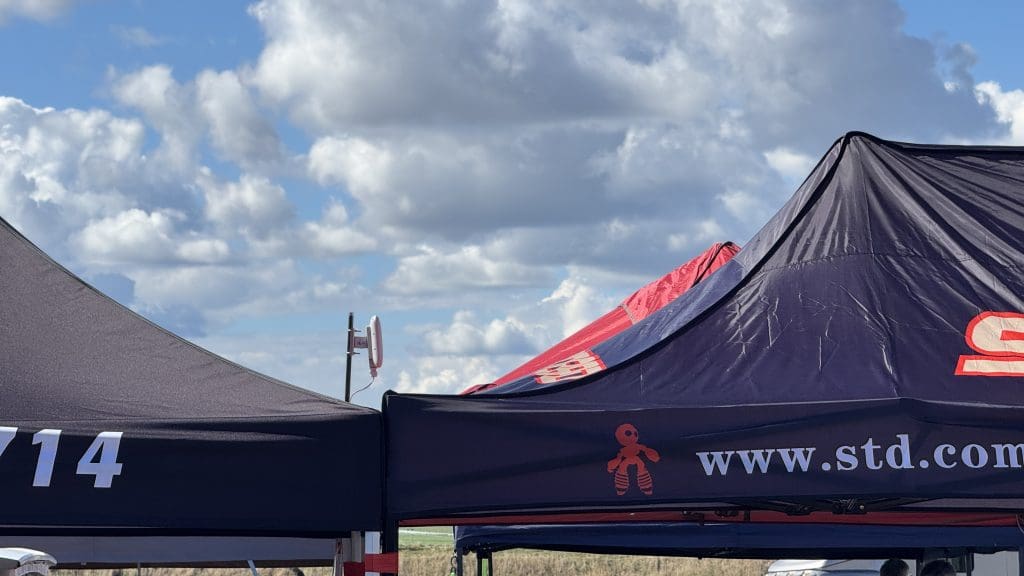 A WombatNET 4G+ Temporary Wi-Fi Receiver attached to a tent with a black cover