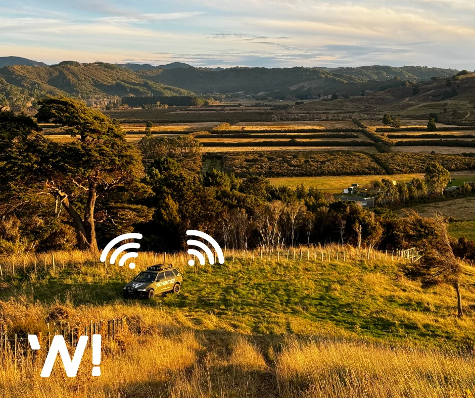 A WombatNET vehicle on hilly countryside terrain with a rural backdrop and cast from the setting sun.